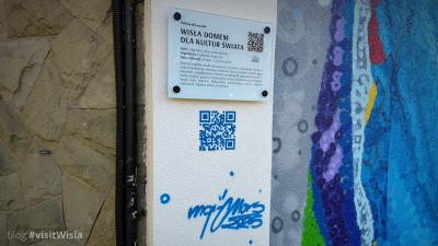 Tablica i sygnatura autora muralu w Wiśle